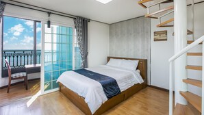 Ein Schlafzimmer mit Bett, Stuhl, Fenster und einer Treppe.