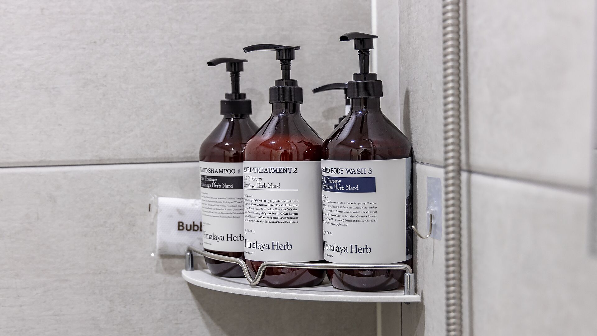 Ein Badezimmerschrank mit drei Flaschen Himalaya Kräuter Shampoo.