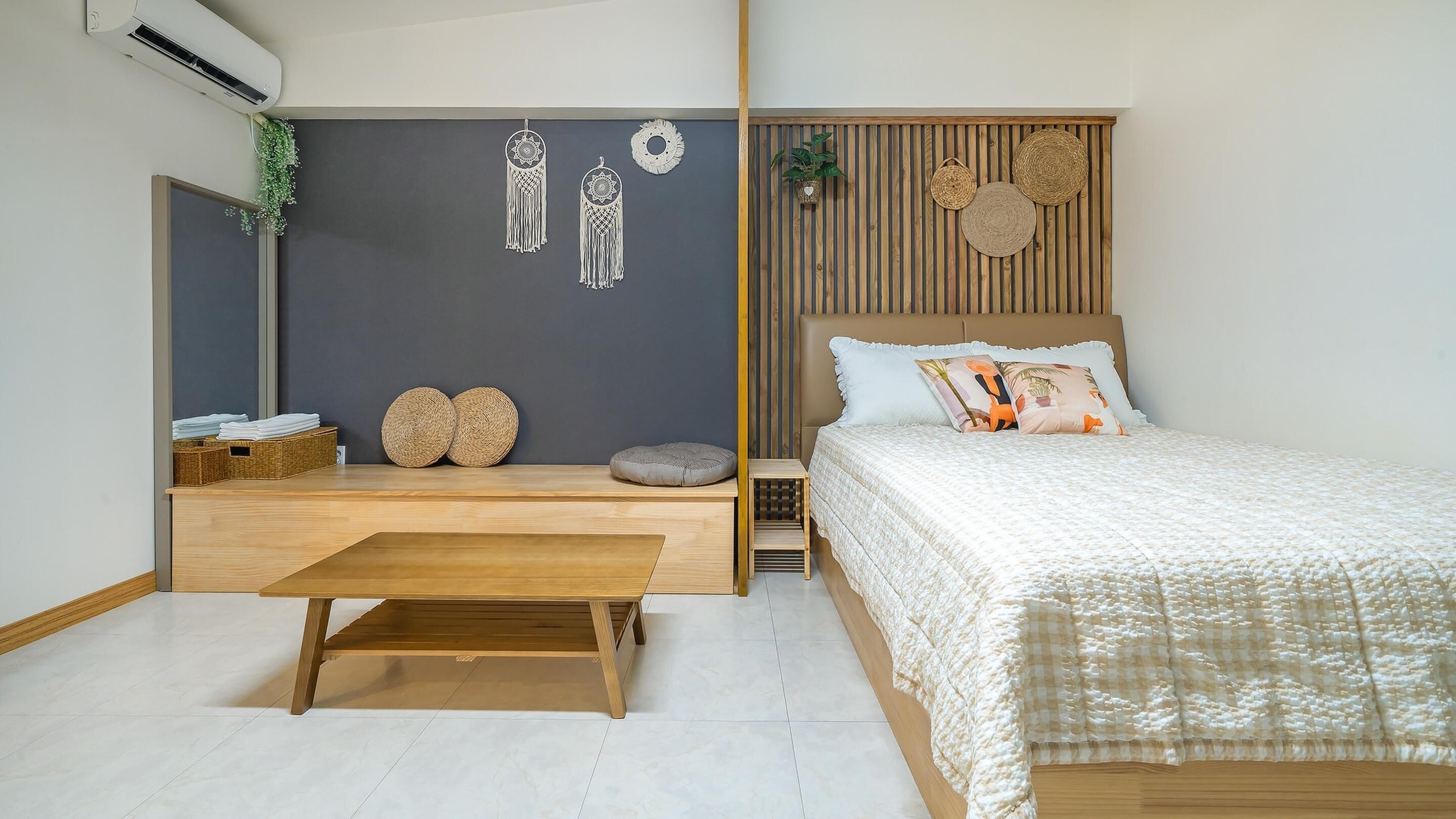 A modern bedroom with a bed, bedside table, and a bench.