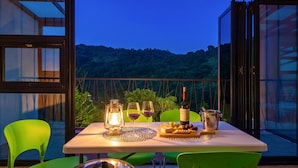 A table set for a meal with a bottle of wine, glasses, a lantern, and a cheese board. - Gapyeong Colline Pension (Gapyeong)