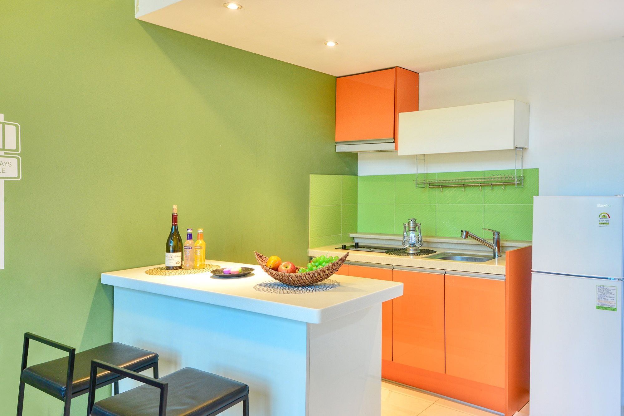 A compact kitchen with a central island, a sink, and a refrigerator.