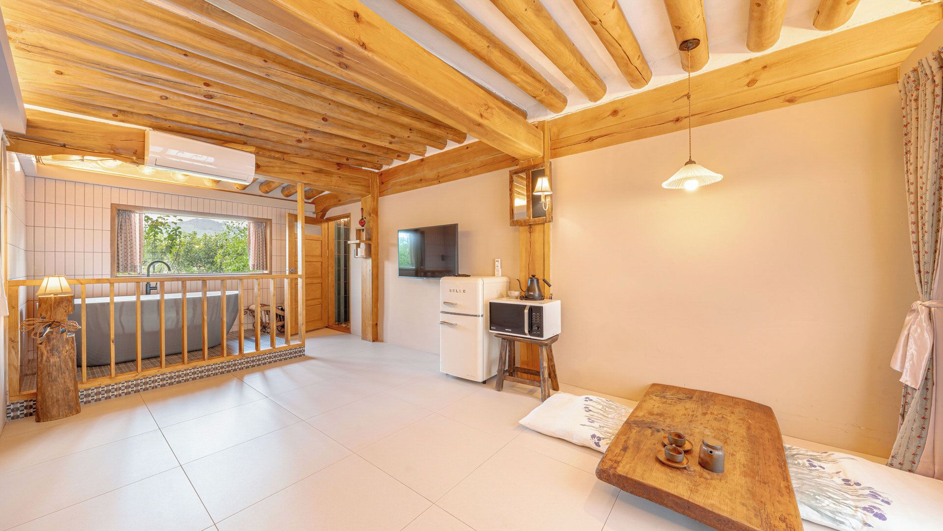 Un interior de madera con balcón, kitchenette y zona de estar.
