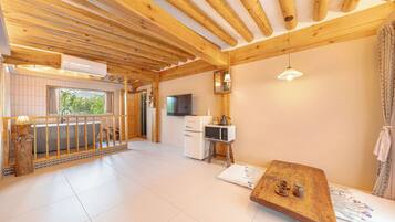 Un interior de madera con balcón, kitchenette y zona de estar.
