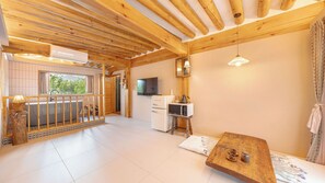 Un interior de madera con balcón, kitchenette y zona de estar.