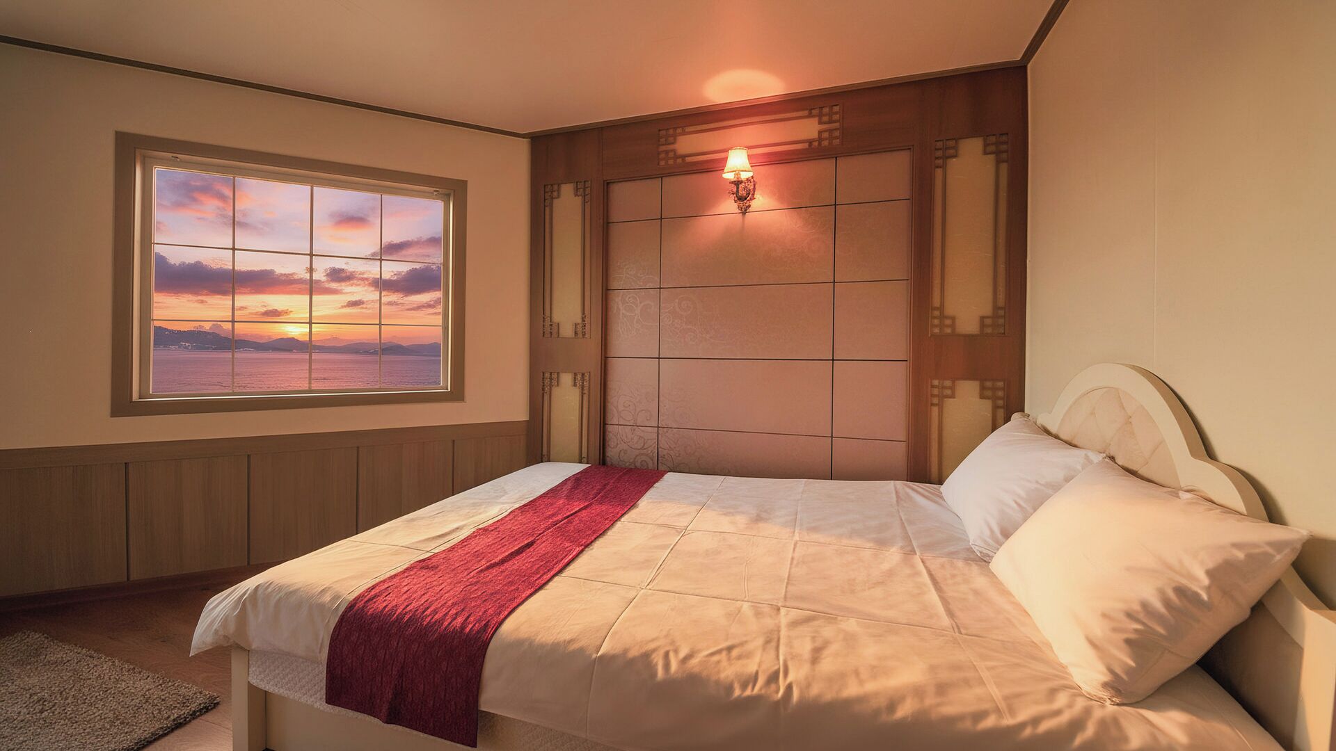 A bedroom with a bed, a window with a sunset view, and a wall-mounted light fixture.