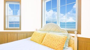 A bedroom with a bed, two windows, and a view of the sea. - Ganghwa Bettel Pension (Incheon)