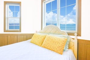 A bedroom with a bed, two windows, and a view of the sea. - Ganghwa Bettel Pension (Incheon)