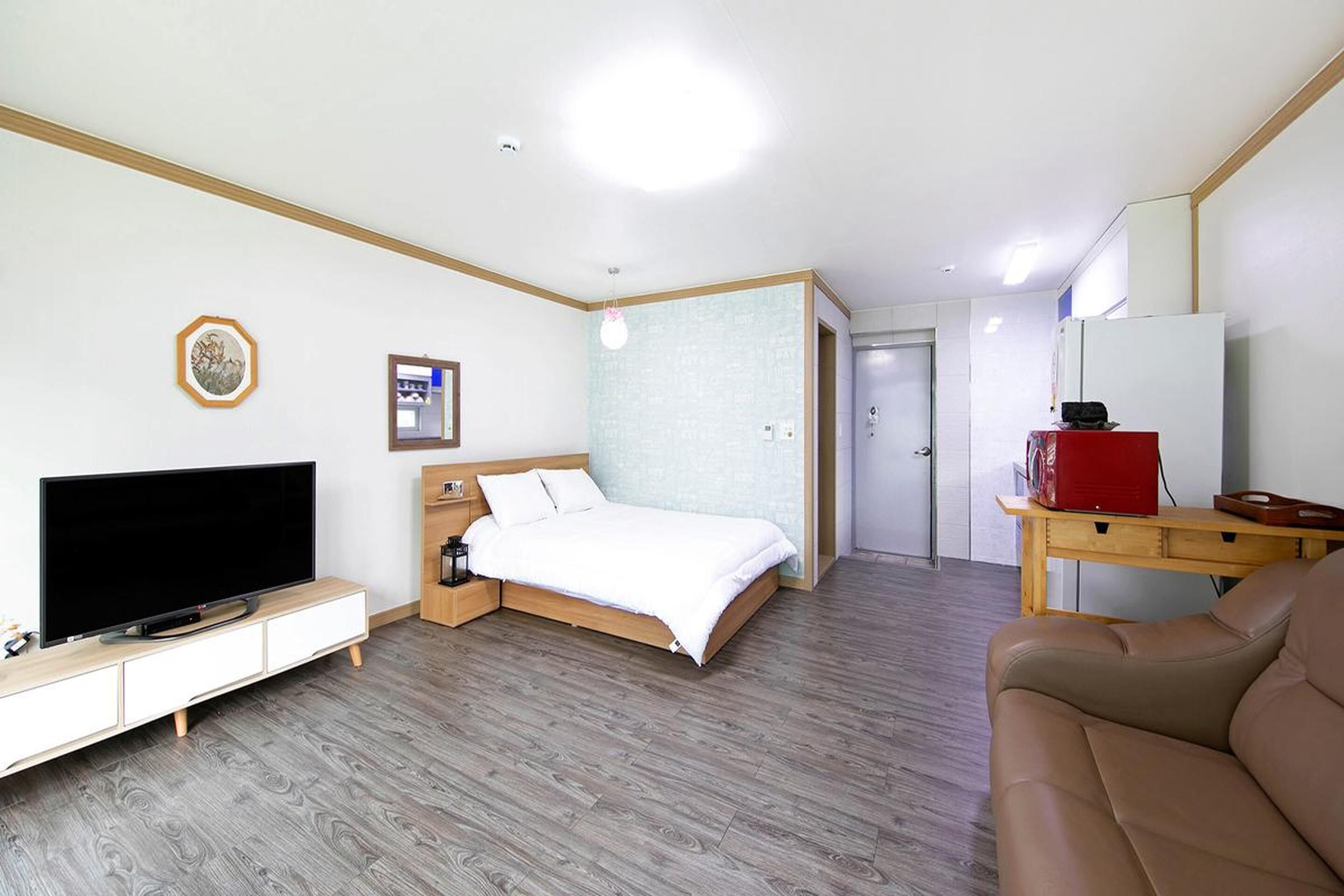 Una habitación de hotel con cama, televisión, escritorio y sofá.