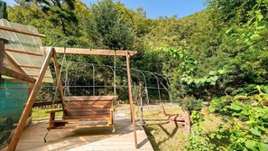 A wooden deck with a swing set and a rope ladder, surrounded by dense greenery and trees. - Hongcheon When You Are There Pension (Hongcheon)
