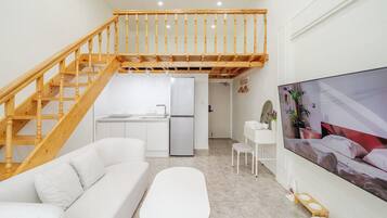Um interior moderno com escada de madeira, cozinha, sofá branco e uma grande moldura na parede.