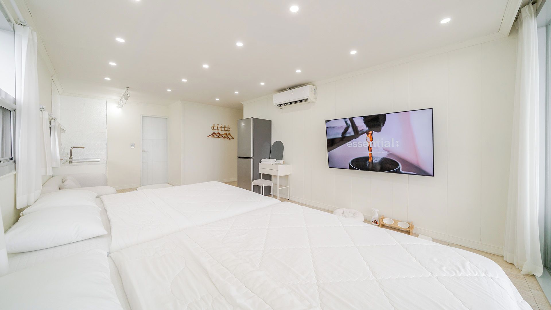 Quarto de hotel com uma cama grande, televisão, guarda-roupa e espelho.