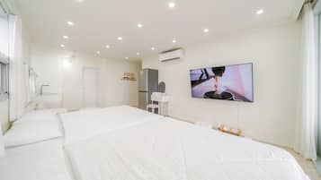 Quarto de hotel com uma cama grande, televisão, guarda-roupa e espelho.