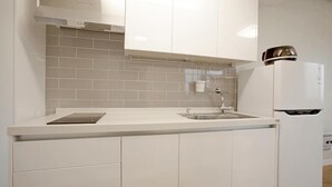 Een moderne keuken met witte kasten, een inbouwoven en een roestvrijstalen afzuigkap.
