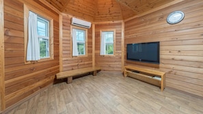A wooden cabin room with a TV, bench, and three windows. - Hwacheon Parprika Yellow Pension (Hwacheon)