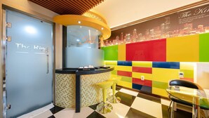 A hotel lobby with a checkered floor, a reception desk, and a colorful wall mural. - Yeosu King Pension Tel (Yeosu)