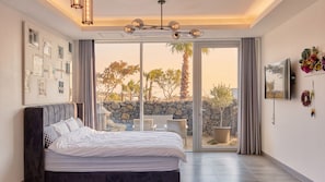 Une chambre à coucher avec un lit, une grande fenêtre et une vue sur l’extérieur.