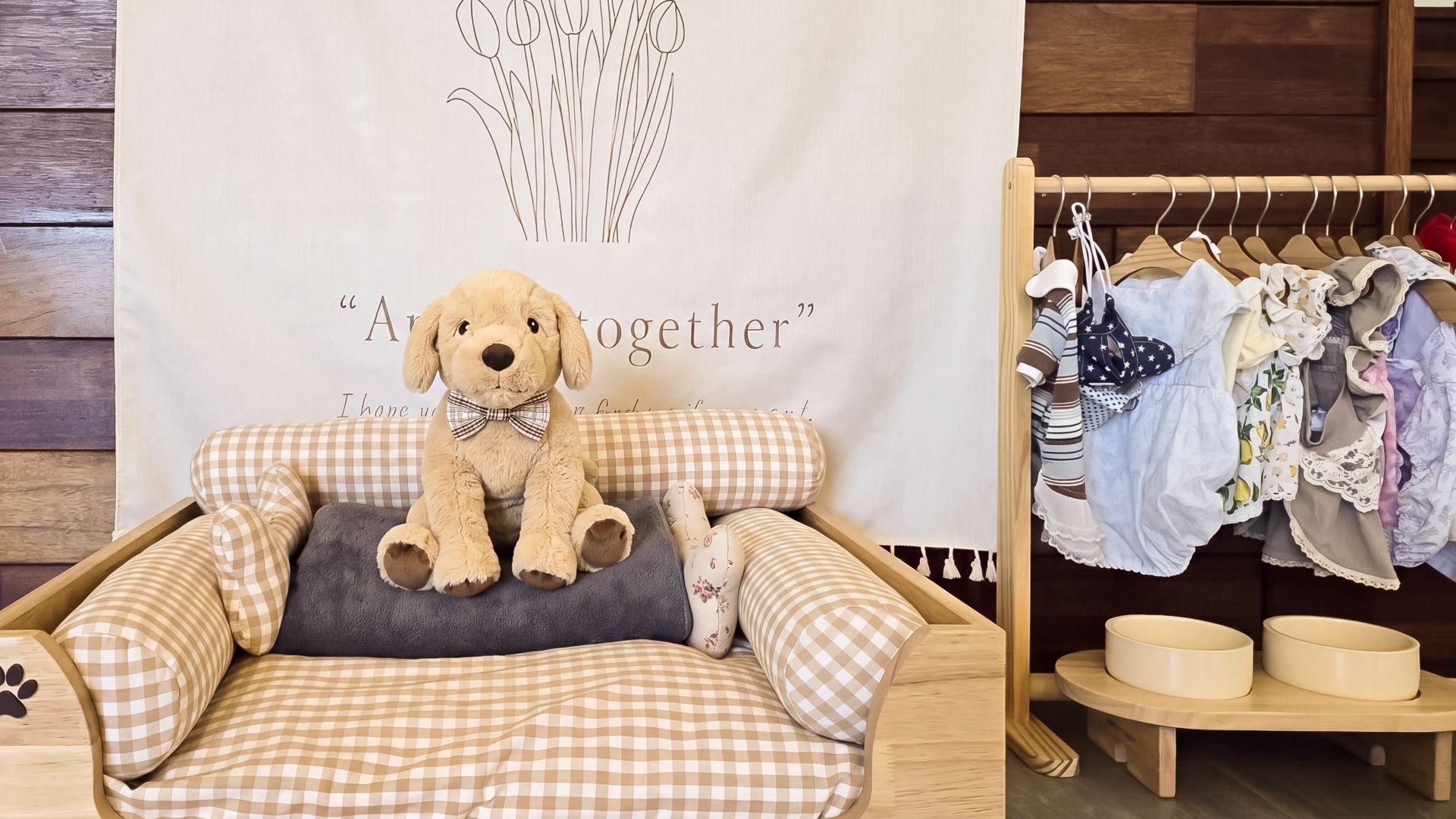 A cozy room with a plush dog bed, a wall with a floral design, and a clothing rack with various garments.