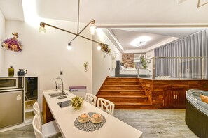Eine moderne Küche mit Essbereich, einer Holztreppe und einer gemütlichen Sitzecke.