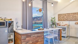 Una cucina moderna con isola in legno, forno a microonde integrato e una grande finestra che si affaccia su una vista cittadina.