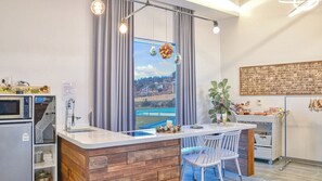 Une cuisine moderne équipée d’un four à micro-ondes encastré, d’un évier et d’un plan de travail en bois.