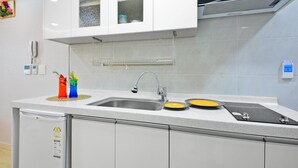 A modern kitchen with a stainless steel sink, a dish rack, and a dish drying mat. - Seogwipo Daepyeong Olleh Pension (Seogwipo)