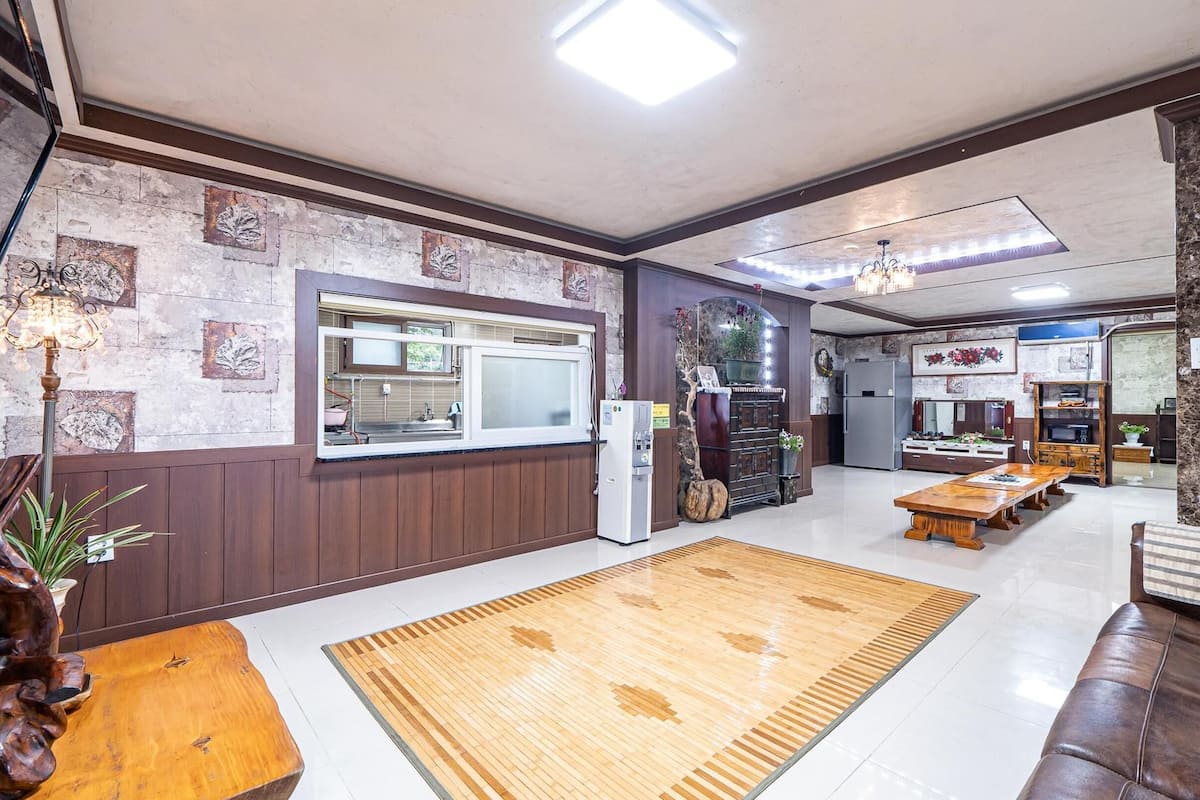 A spacious living area with a wooden coffee table, a sofa, and a rug.