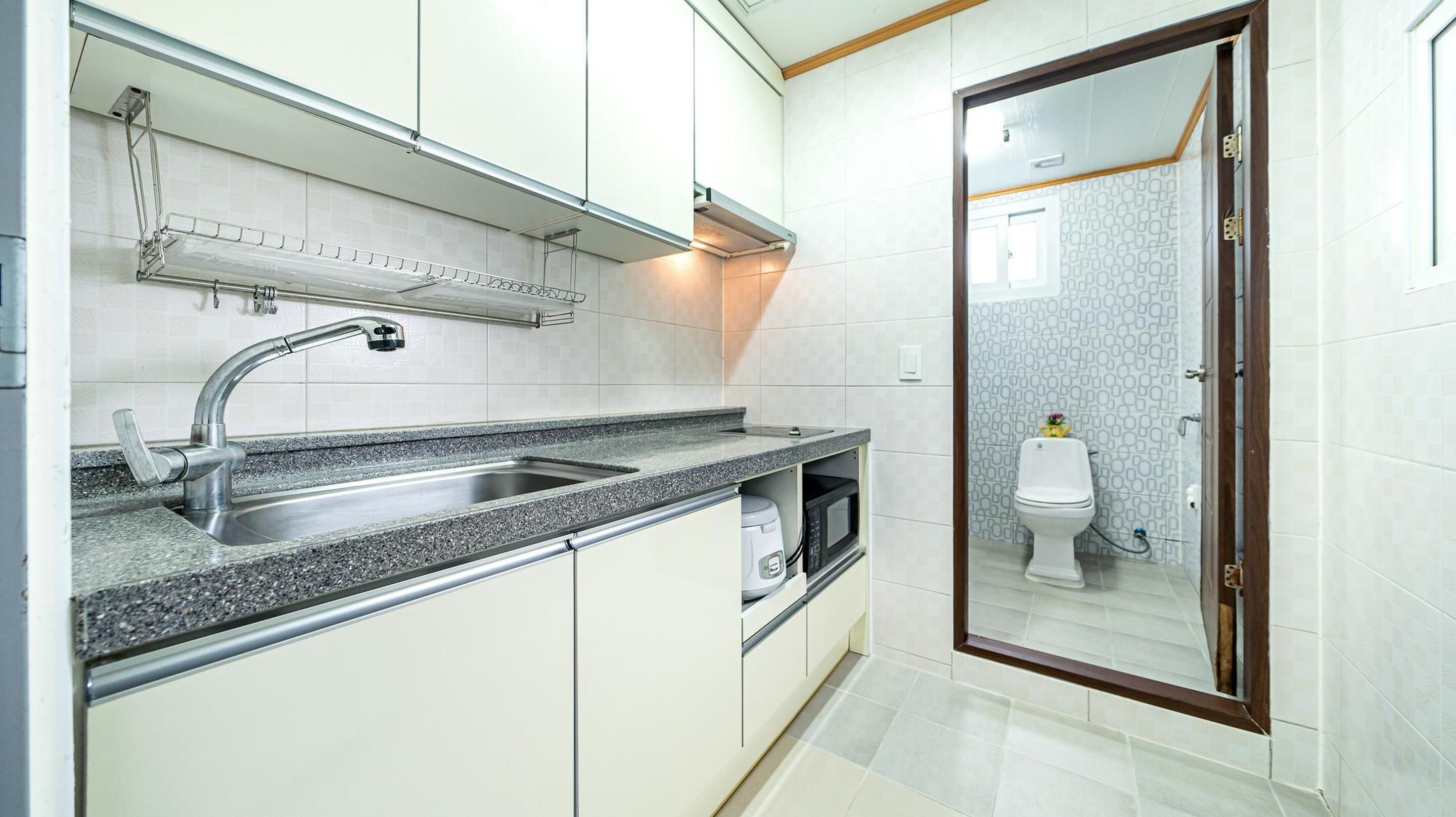 A modern kitchen with a stainless steel sink, a microwave, and a built-in oven.