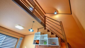 A staircase with wooden railings and a white shelf unit with kitchen items. - Yangpyeong Yoon & Park Spa Pension (Yangpyeong)