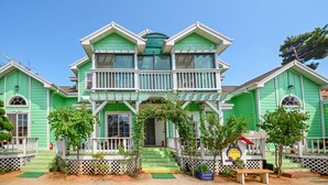 A two-story building with a green facade, a balcony, and a small porch area. - Youngheungdo Roma Spa Pension (Incheon)