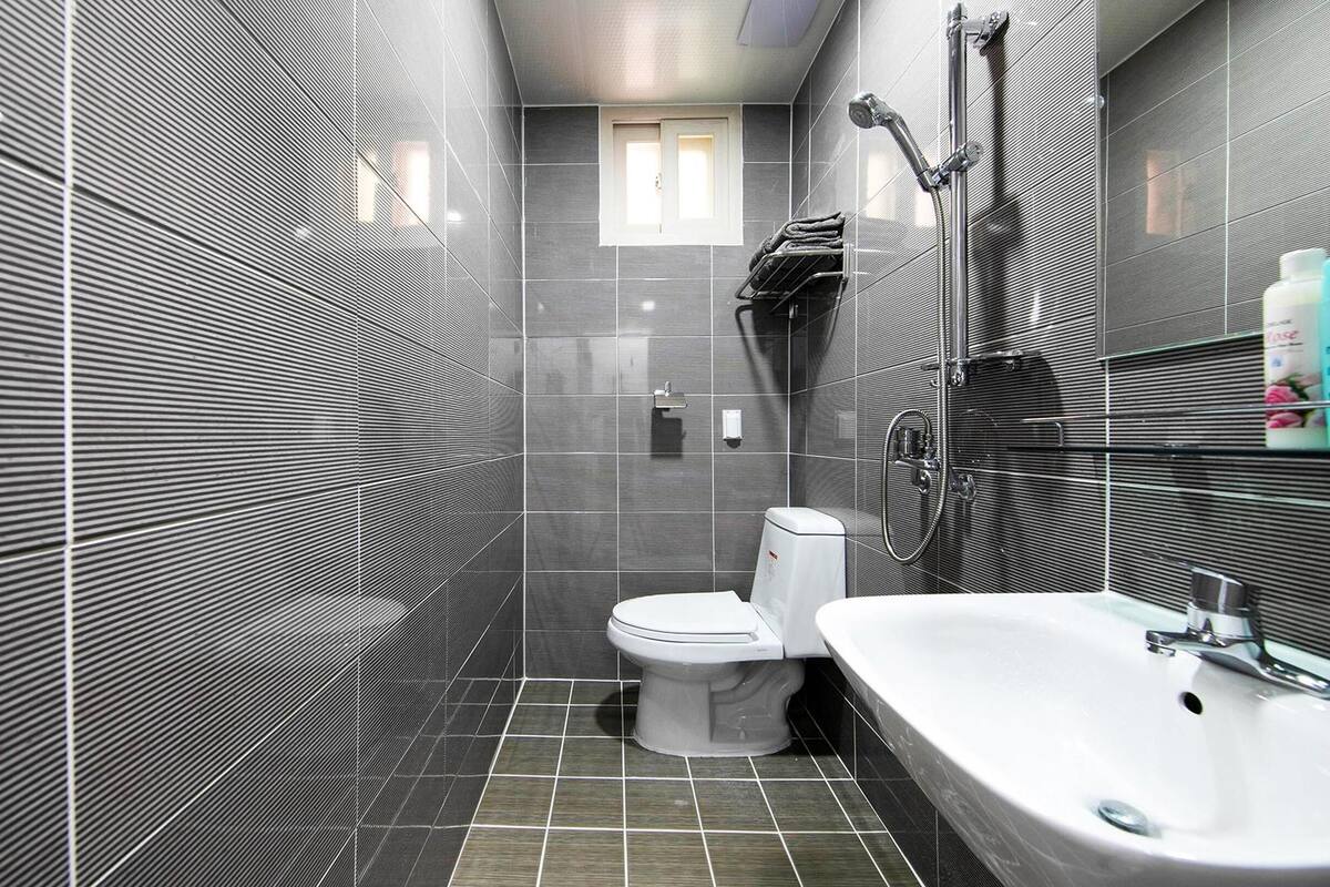 Et moderne badeværelse med toilet, vask og brusebad.
