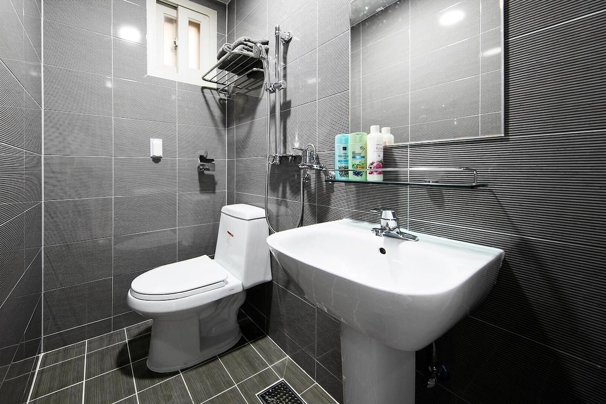 Et moderne badeværelse med toilet, vask og brusebad.