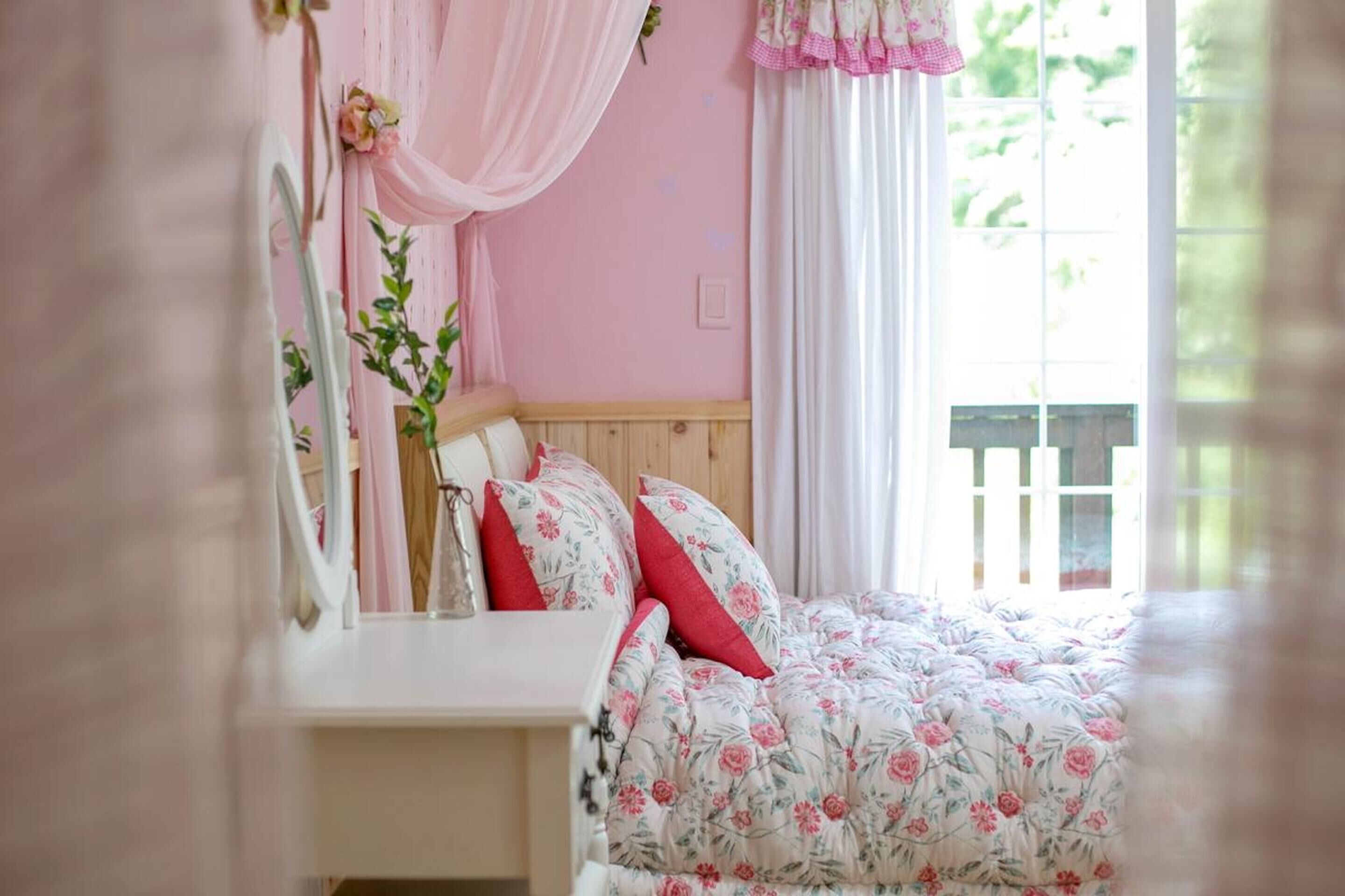 Un dormitorio con colcha estampada, cabecera de madera y mesita de noche con espejo.