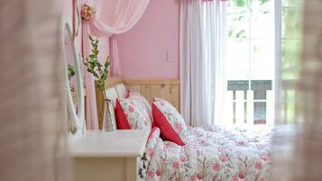 Un dormitorio con colcha estampada, cabecera de madera y mesita de noche con espejo.