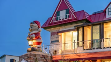 Un edificio con techo rojo y una estatua de un oso sosteniendo un farol.