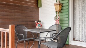 Un patio con una mesa y sillas, un farol decorativo y una figura de muñeco de nieve.