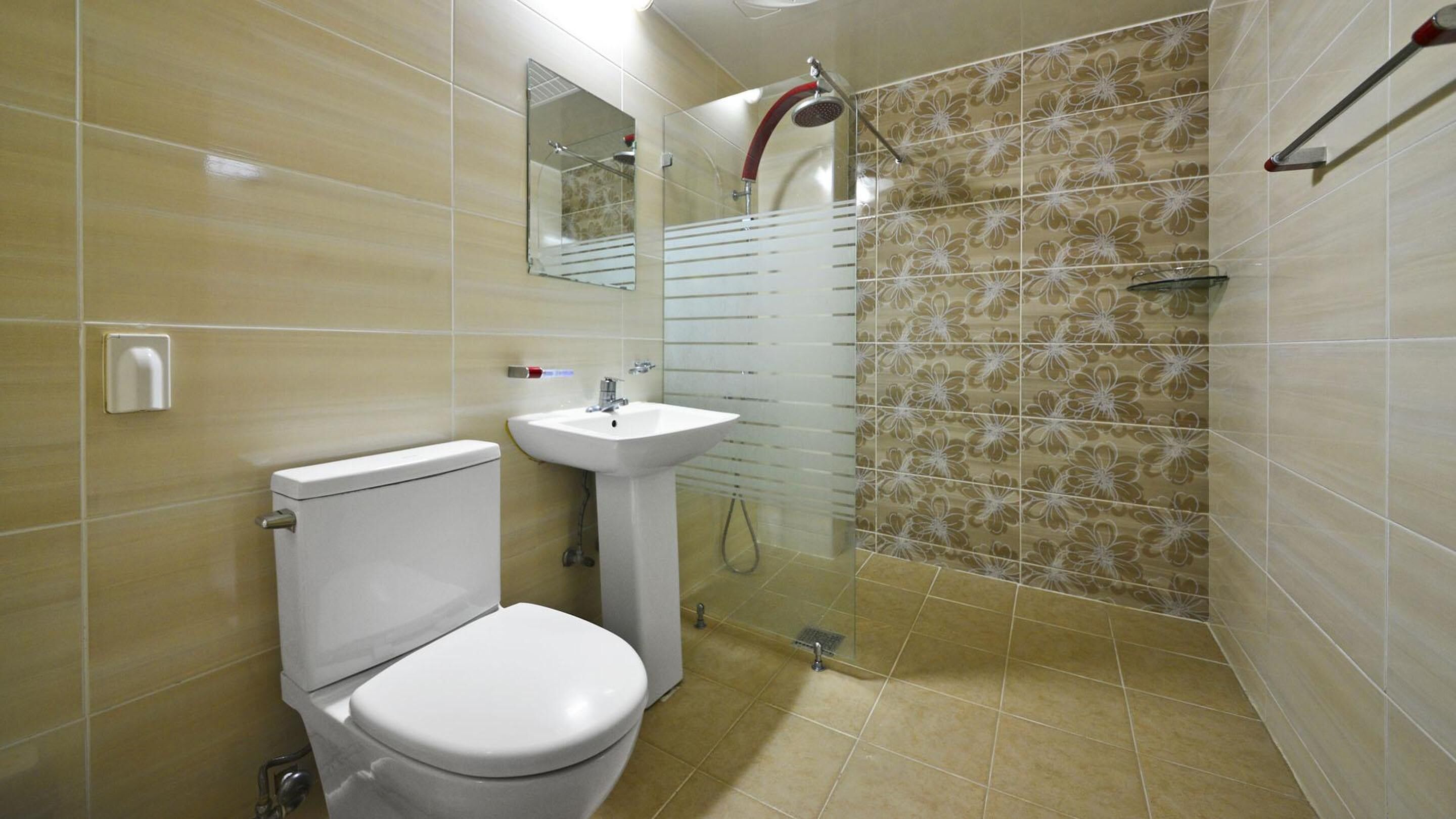 A bathroom with a toilet, sink, and shower.