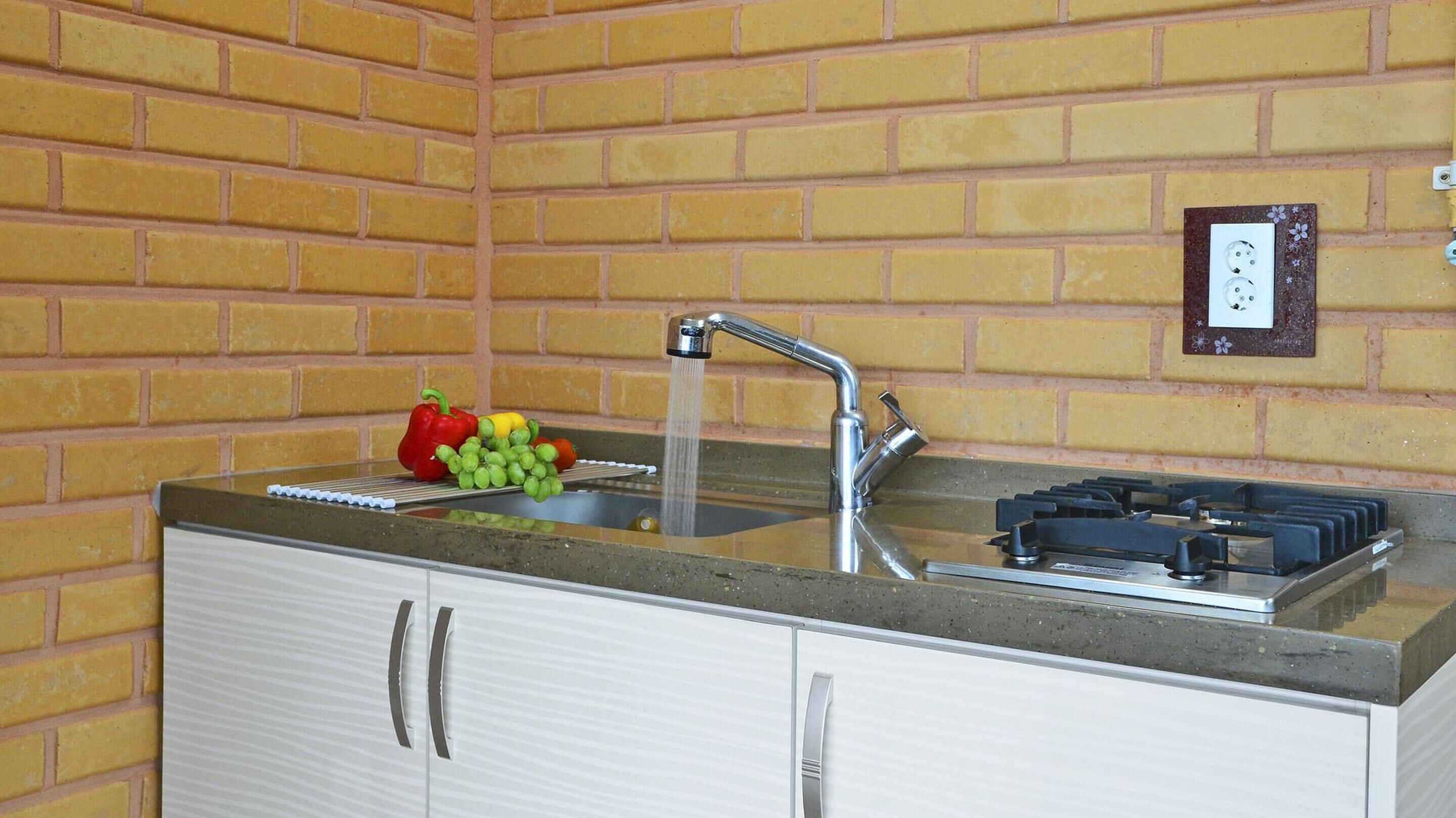 A kitchen with a sink, faucet, and a gas stove.