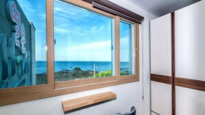 Une pièce dotée d’une grande fenêtre donnant sur une côte rocheuse.