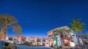A row of beachfront villas with a clear night sky, palm trees, and a well-lit entrance. - Jeju Kiaora Resort (Seogwipo)
