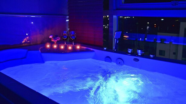 Een jacuzzi met uitzicht op de stad 's nachts.