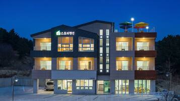 A multi-story hotel with a modern design, featuring balconies and large windows.