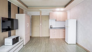 Une cuisine moderne avec des meubles en bois, un téléviseur encastré et un réfrigérateur.