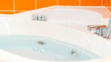 Una bañera con agua corriente, un desagüe y dos llaves.