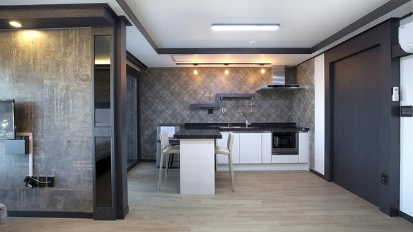Una cocina moderna con una isla central, horno empotrado y microondas.