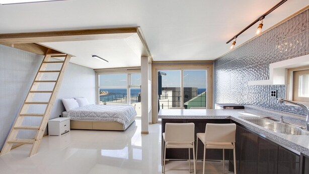 A modern apartment with a loft bedroom, a kitchen with a view, and a balcony. - Donghae Haru Pension (Donghae)
