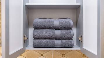 A white cabinet with a textured gray towel folded inside.