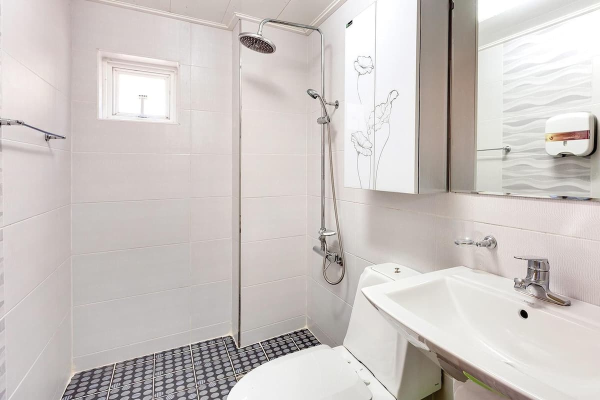 Une salle de bain moderne équipée d’une douche, de toilettes et d’un lavabo.