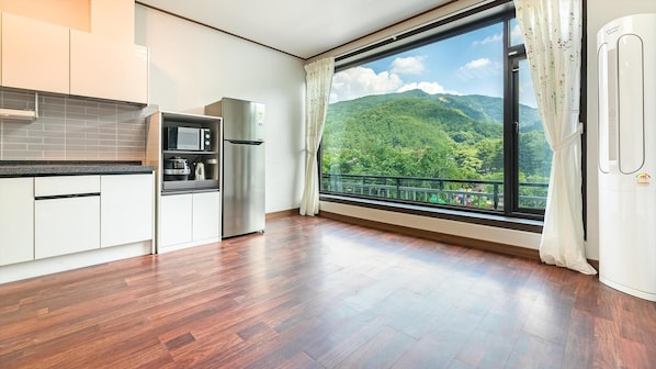 Une cuisine moderne dotée d’une grande fenêtre donnant sur un paysage montagneux.