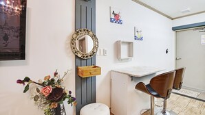 A bathroom with a mirror, a wooden box, a white sink, and two bar stools. - Geoje Badasunjang Pension (Geoje)