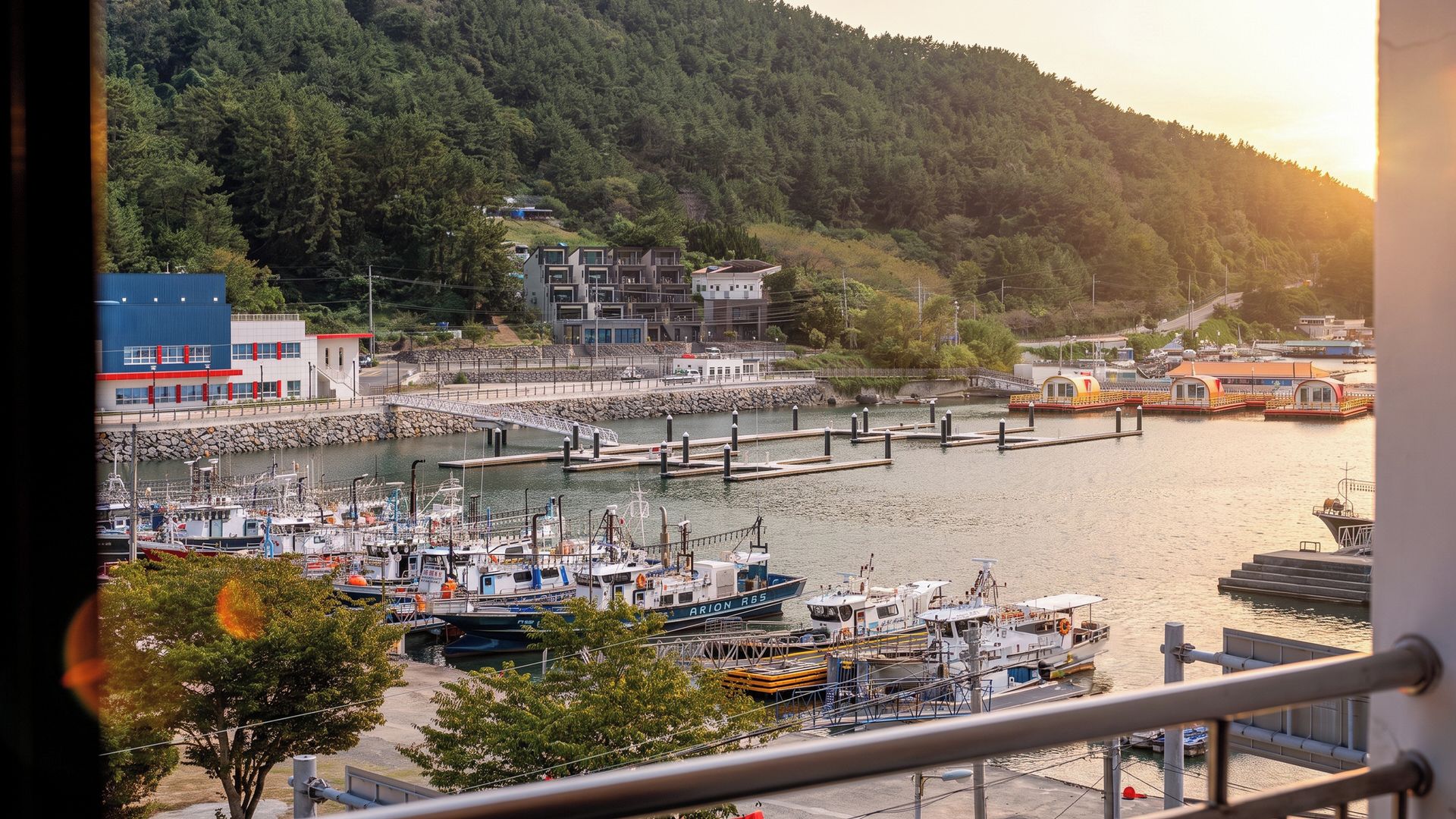 Un puerto deportivo con barcos amarrados, un puente y edificios al fondo.